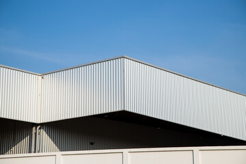 Warehouse Factory Industry Building with Geometric Metal Corrugated Steel Wall and Rooftop against Blue Sky Background, Modern Industrial Exterior Architecture Backdrop Structure in Minimal Style