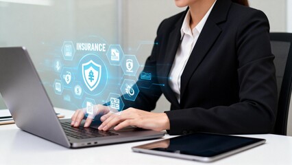 Businesswoman working on laptop with insurance icons