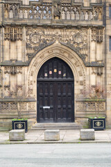 Manchester cathedral  Entrance With Ornate Archway And Planters On Quiet Urban Street