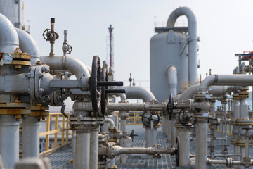 Large industrial plant with many pipes and valves. The valves are all closed. Scene is industrial and serious