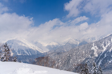 冬の新穗高に連なる雪山と雲の風景