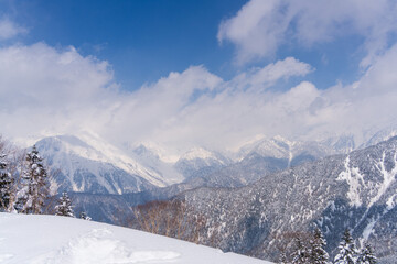 Fototapeta premium 冬の新穗高に連なる雪山と雲の風景