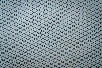 Expanded metal mesh with diamond pattern forming a strong industrial texture, suitable for background, construction, safety, and architectural design concepts.