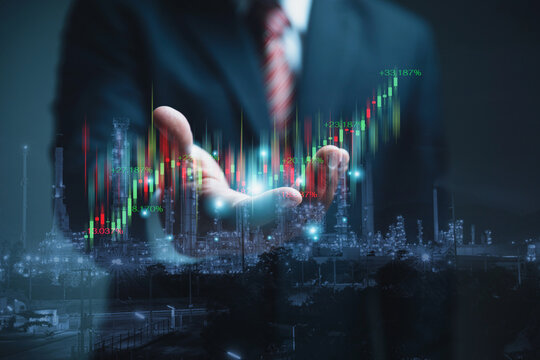 A businessman in a suit is holding a digital financial stock market graph with a growing trend. - Powered by Adobe