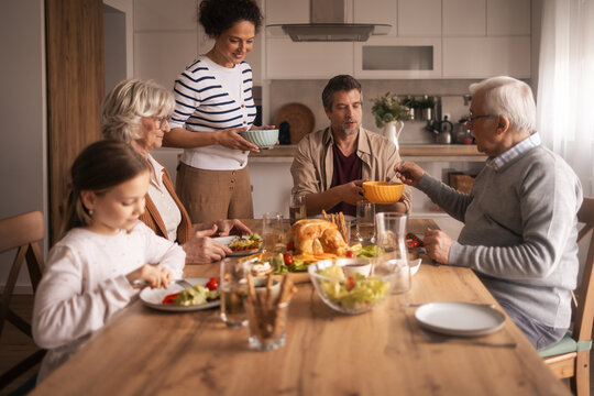 Multi-generational diverse family enjoying lunch together at home