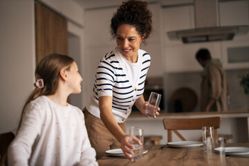 Mother and daughter setting table for family lunch