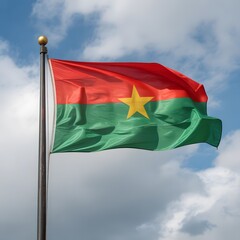 The flag of Burkina Faso waving in the wind against a cloudy sky