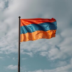 The Armenian flag waving in the wind against a cloudy sky