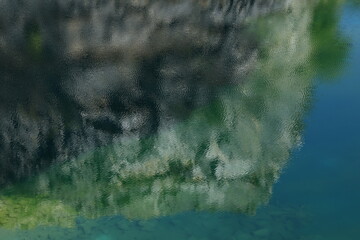 The colors and details on the water's surface as the wind blows, reflecting the limestone mountain. 
Blue Lagoon (emerald-blue pond)  in  Phu Pha Man ,Khon Kaen proviince ,THAILAND