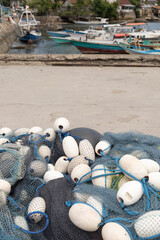 Obraz premium For over a month, strong winds have been alternatingly passing through Sumba, with boats taking shelter at the dock and local fishermen mending torn fishing nets