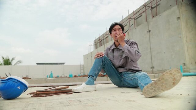 First Aid safety first and accident concept. Asian japanes Professional Engineering or construction builder worker in safety hard hat helmet lying unconscious at construction site. Civil engineer