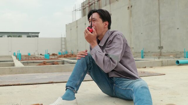 First Aid safety first and accident concept. Asian japanes Professional Engineering or construction builder worker in safety hard hat helmet lying unconscious at construction site. Civil engineer