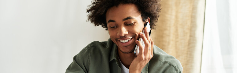 Handsome young african american man enjoying a cozy moment at home while talking on the phone
