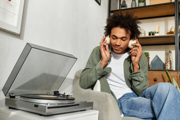 Listening to music in a cozy modern home, a young man enjoys a peaceful moment