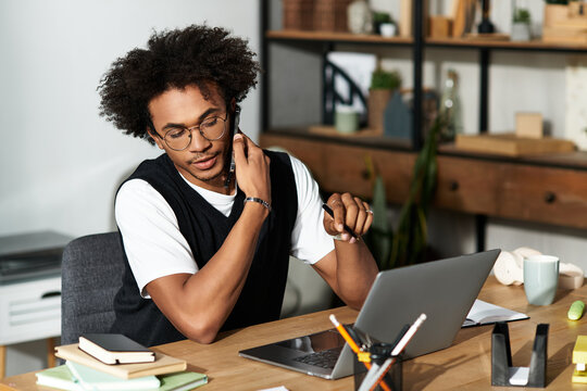 Young african american man enjoying a productive day at his cozy modern home office - Powered by Adobe