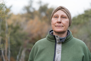 Mature woman cancer survivor wearing head scarf outdoors