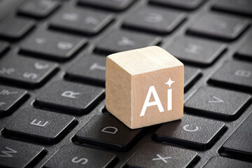 Wooden block with artificial intelligence symbol on computer keyboard