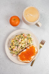 Russian breakfast on January 1st. Olivier salad, toast with butter and red caviar, and coffee.