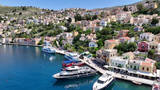 Aerial drone cinematic video of picturesque seaside main town and port of Yialos of Symi island with colorful neoclassical houses and traditional character, Dodecanese, Greece