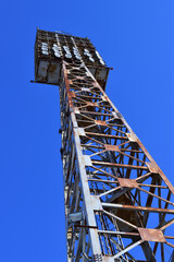 A stadium floodlight mast against a blue sky