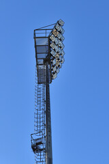 A stadium floodlight mast against a blue sky