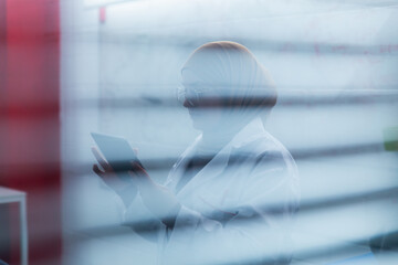 Muslim female scientist in hijab working with digital tablet in laboratory