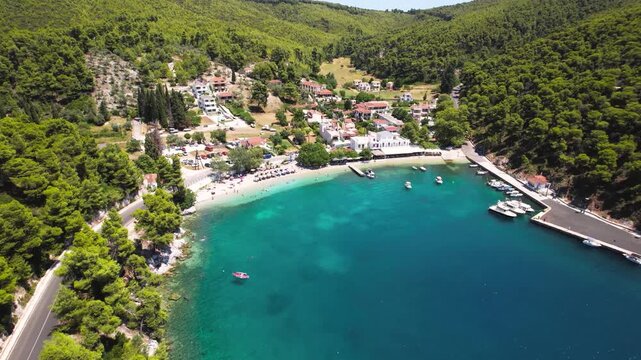 drone view of Agnontas beach and fishing port at Skopelos island. Scenic coastal village with crystal clear water, Greece