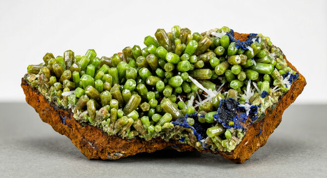 Druse of barrel shaped pyromorphite crystals hexagonal form with bright green color and on a rusty-brown limonite matrix
