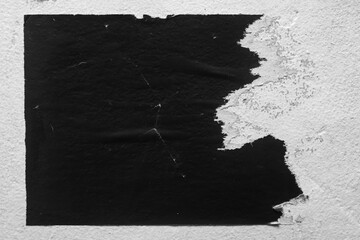 An old torn black poster with no inscriptions.
