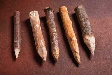 several wooden stakes on a brown background close-up