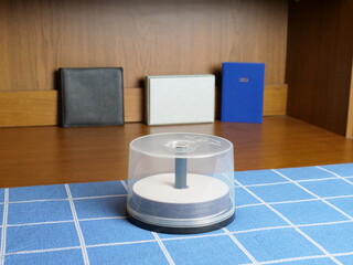 mpty compact disc spindle in a transparent case on a desk, organization of digital media.