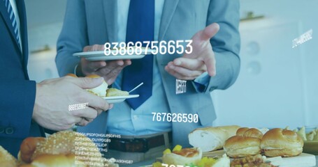 Gesturing with tablet, two men in suits holding plates at office buffet with data overlays
