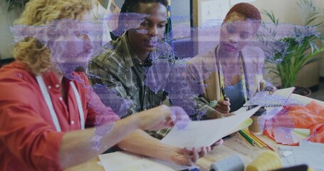 Meeting team in studio wearing red shirt with measuring tape, reviewing patterns with purple map