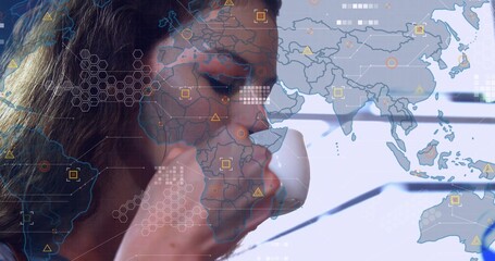 Sipping woman in dark top holding white mug, studying world map HUD at desk, copy space