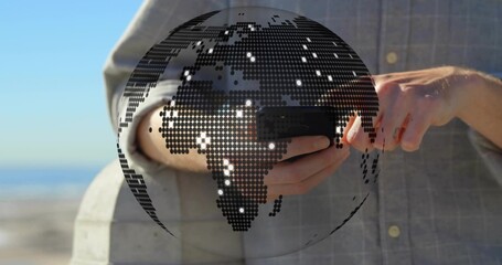 Standing man in gray checked shirt holding phone tapping screen at stone rail, dotted globe overlay