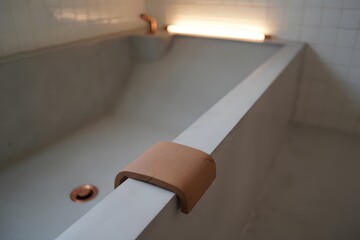 Modern Concrete Bathtub with Copper Fixtures and Leather Accent