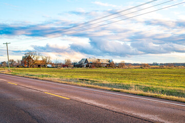 Open agricultural fields extend across the countryside with a small farmstead visible in the distance under a wide autumn sky in rural Ontario.