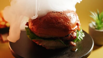 Burger on a plate with lettuce and tomato in a simple setting at a casual dining spot
