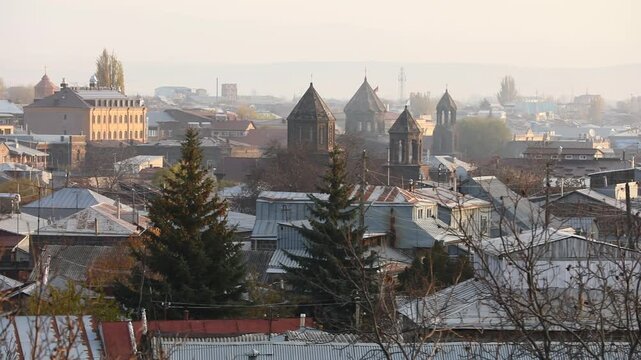 Panoramic view of Gyumri, Armenia, featuring traditional architecture. Majestic snow-capped peaks of Mount Aragats rise in the background under a clear blue sky during a sunny autumn day.


