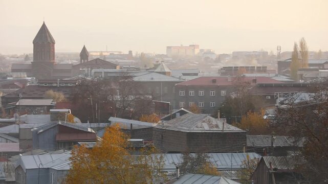 Panoramic view of Gyumri, Armenia, featuring traditional architecture. Majestic snow-capped peaks of Mount Aragats rise in the background under a clear blue sky during a sunny autumn day.

