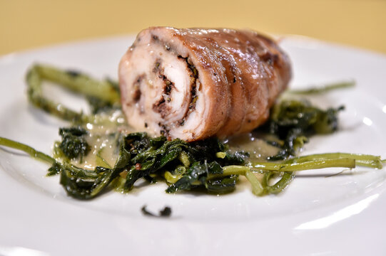 Roll&egrave; di coniglio in porchetta whit chicory or stuffed rabbit rolls is typical food from  Rome and Lazio region in Italy