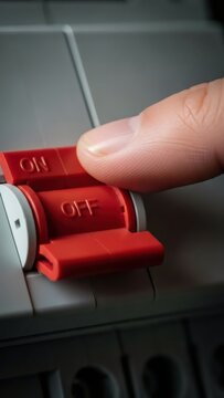 Man&rsquo;s finger turning off an electrical safety breaker switch marked ON/OFF. Power outage or electrical circuit protection concept for home automation.