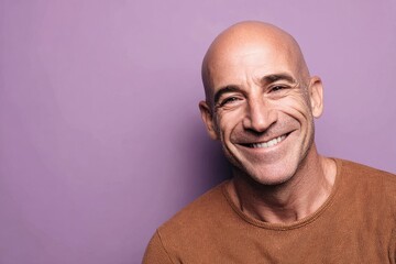 Obraz premium Bald middle aged man smiling on purple background cancer awareness and survivor strength