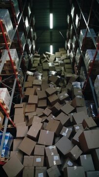 Logistics supervisor surveying massive cardboard box collapse in distribution center. Panning shot of warehouse accident.