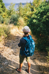 Teenage boy hiking in summer with a backpack. Outdoor adventure, active lifestyle, and exploration in nature, perfect for travel and summer leisure concepts.