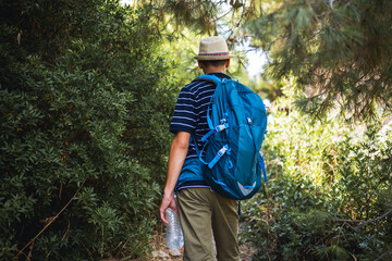 Teenage boy hiking with a backpack in summer. Outdoor adventure, freedom, and youthful exploration, ideal for travel, lifestyle, and nature-themed content.