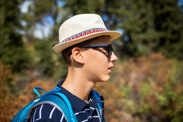 Teenage boy hiking with a backpack in summer. Outdoor adventure, freedom, and youthful exploration, ideal for travel, lifestyle, and nature-themed content.