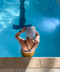 Women Preparing to Swim in an Indoor Pool With Clear Water and Tiled Edge
