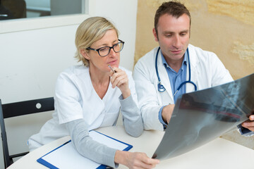 doctors inspecting a patients x-ray