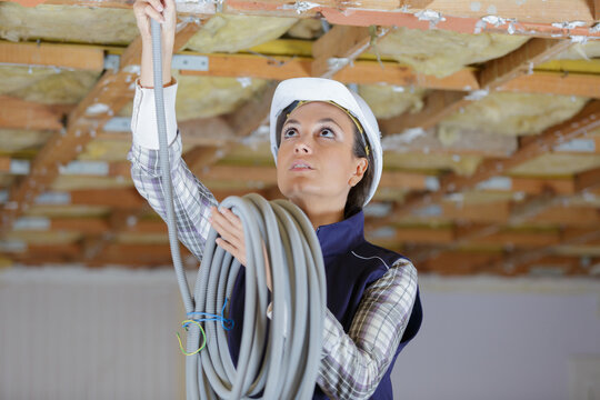 female electrician fitting air conditions pipes